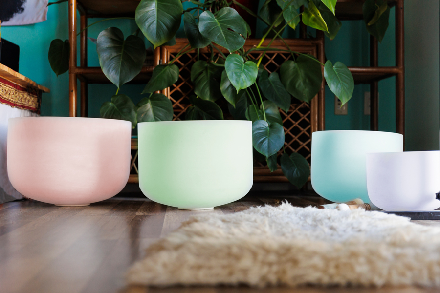 Colorful crystal singing bowls on wooden floor