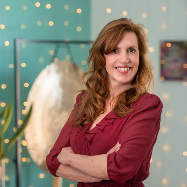Smiling woman in red dress with fairy lights background